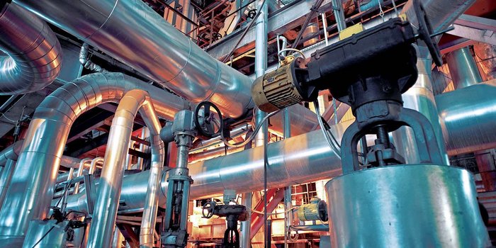 Gezeigt wird ein komplexes Anlagensystem mit Rohrleitungen in einem Industriebetrieb. Foto: © 358191950_nostal6ie / Shutterstock.com