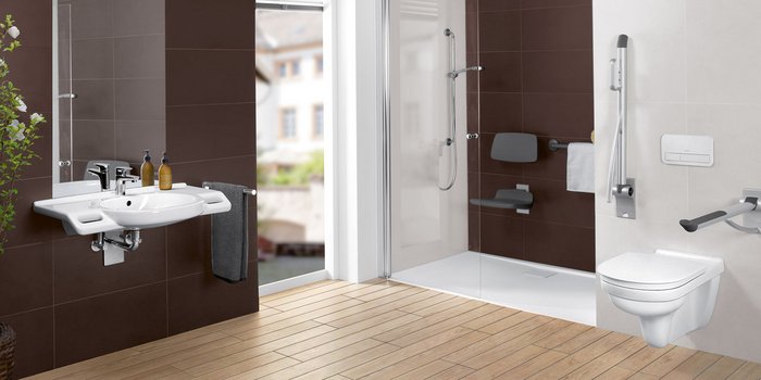 Ein modernes Badezimmer mit einem weißen Waschbecken, einem großen Spiegel und einer Dusche mit Glasabtrennung.