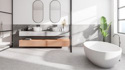 Ein modernes Badezimmer mit einer freistehenden Badewanne und eleganten Waschbecken auf einer grauen Arbeitsplatte.